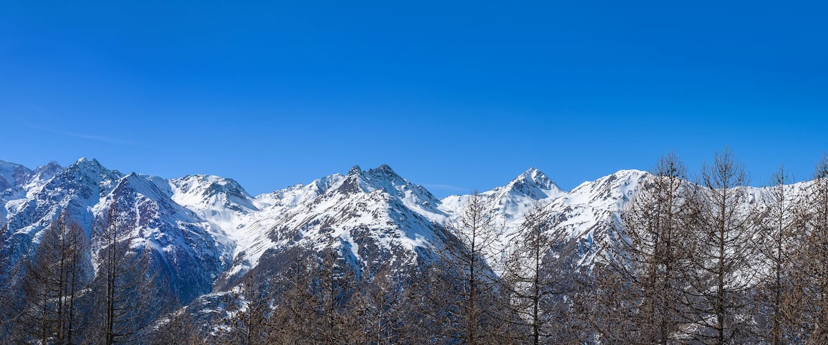 A snow-covered mountain range with clear blue skies.