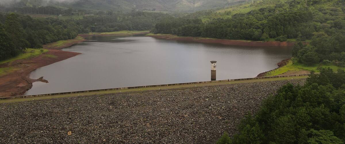 A large reservoir surrounded by forested hills.