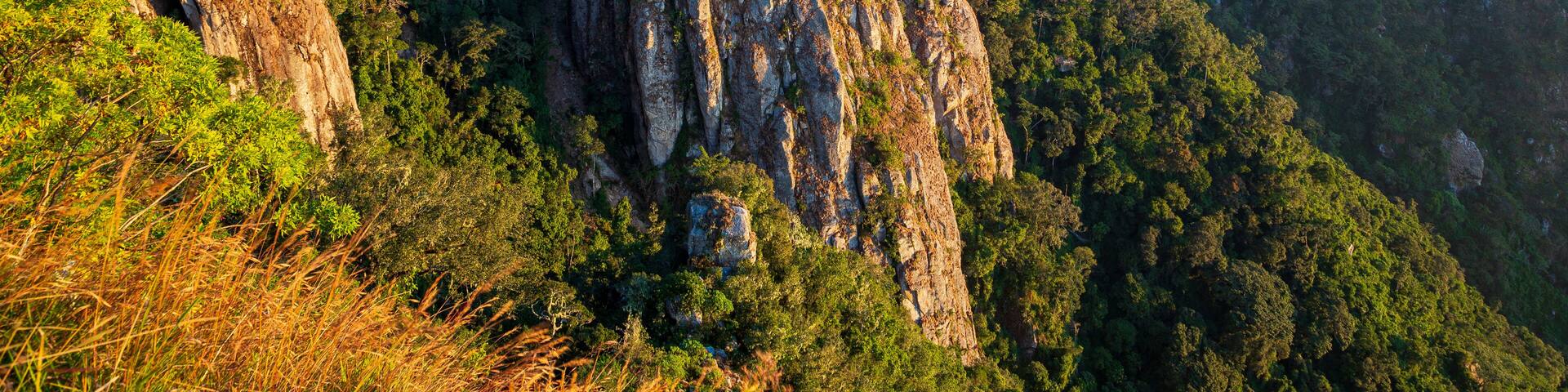 A mountainous landscape with steep cliffs and dense green vegetation.