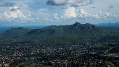 A mountainous landscape with a town in the foreground and a range of hills in the background.