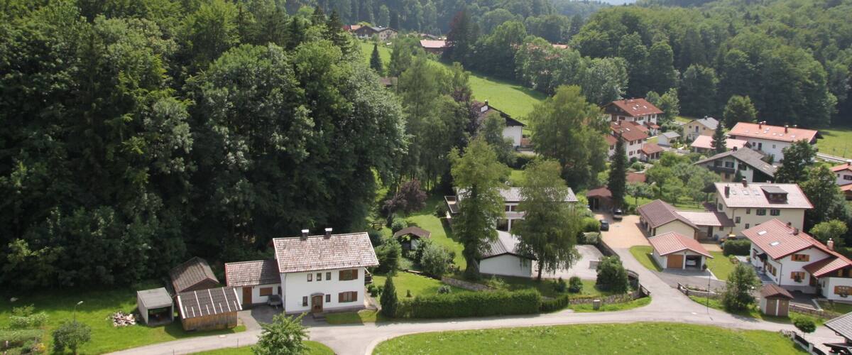 A village nestled in a valley surrounded by lush green mountains.