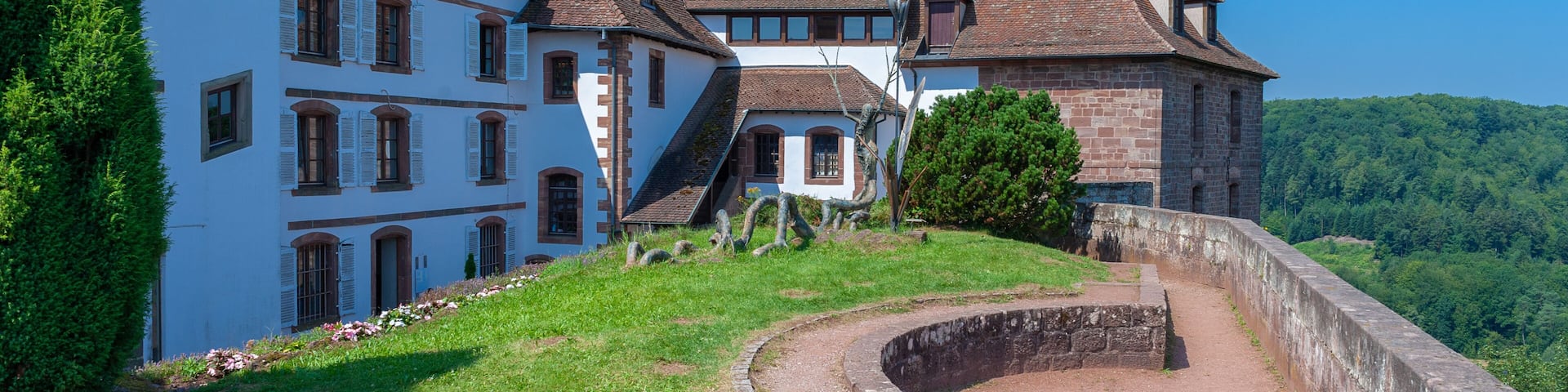 A historic building with a stone wall and a clear blue sky.