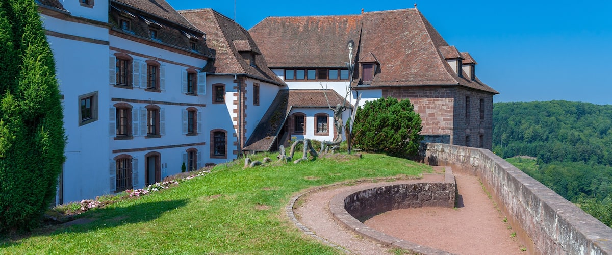 A historic building with a stone wall and a clear blue sky.
