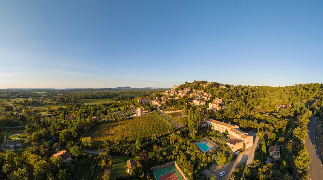 Aerial view of a picturesque village surrounded by tranquil fields and trees at sunset, Moissac-Bellevue, Var, France.