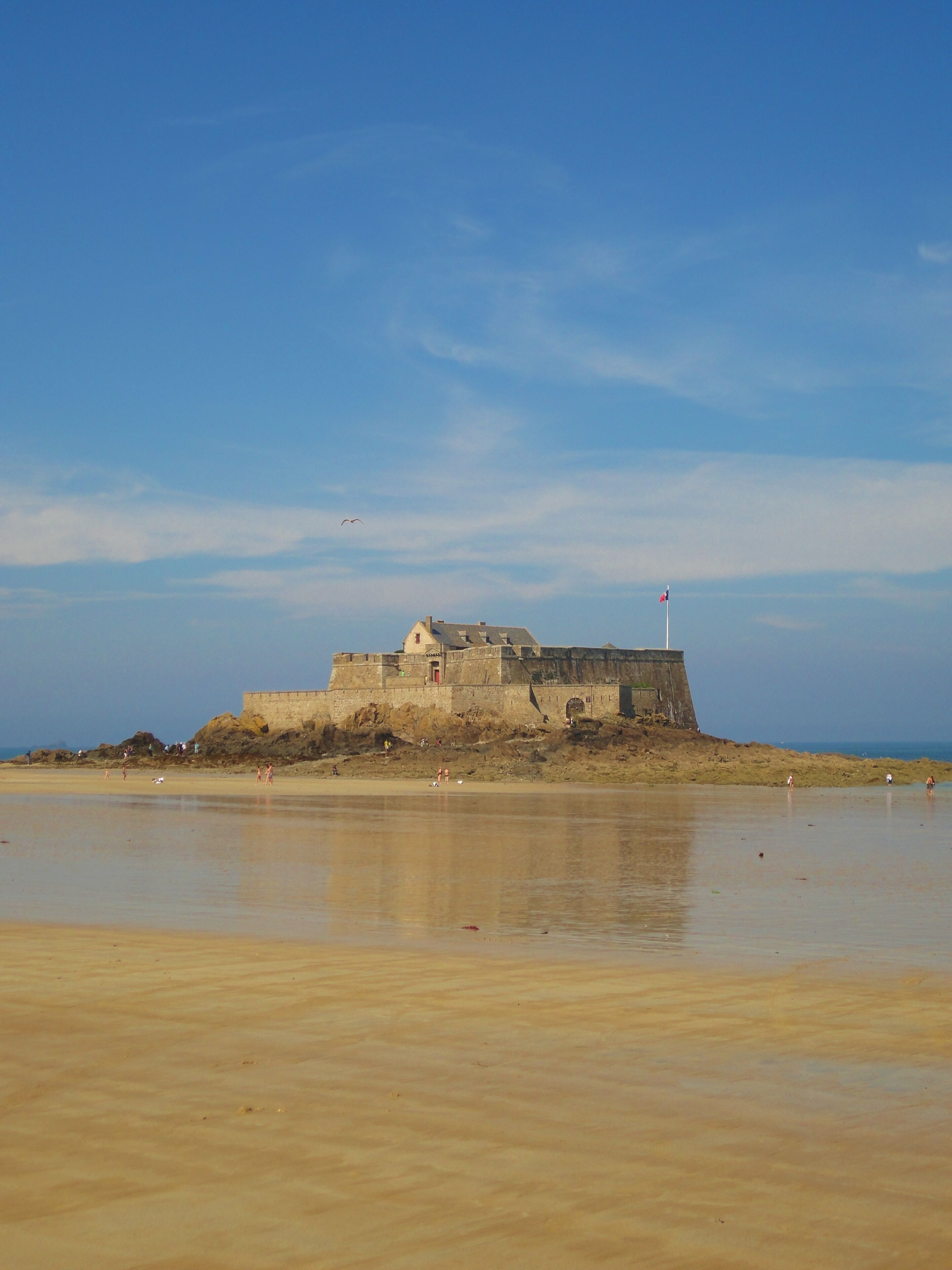 A coastal fortification with a sandy beach in the foreground.