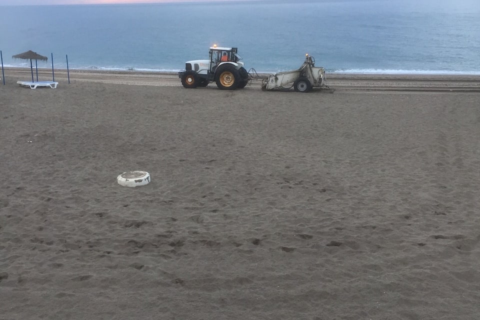 A beach with a tractor and a trailer.