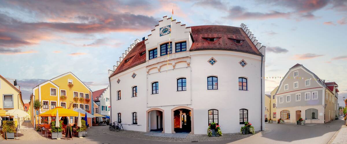 A historic building with a clock tower, surrounded by cobblestone streets and traditional European architecture.