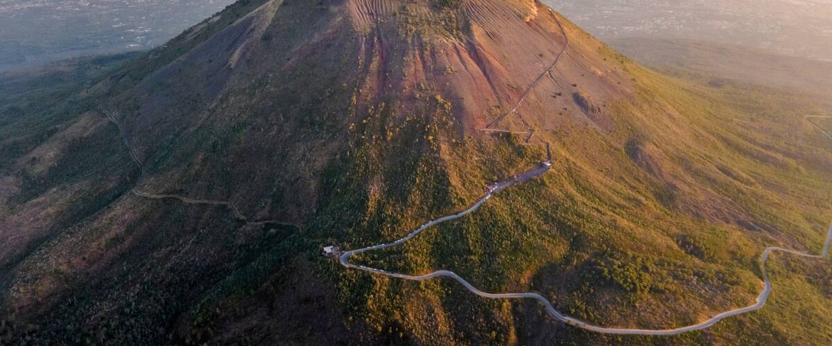 A mountain with a winding road and a small settlement at its base.
