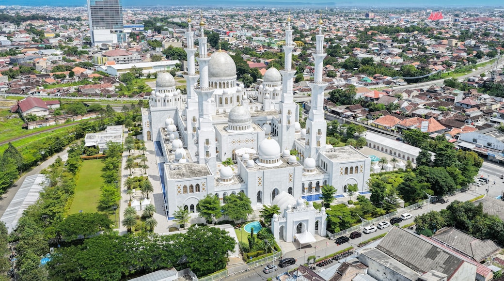 Aerial view of the Sheikh Zayed Grand Mosque Solo Surakarta with its white domes and minarets surrounded by the urban landscape of the city Kecamatan Banjarsari, Jawa Tengah, Indonesia.