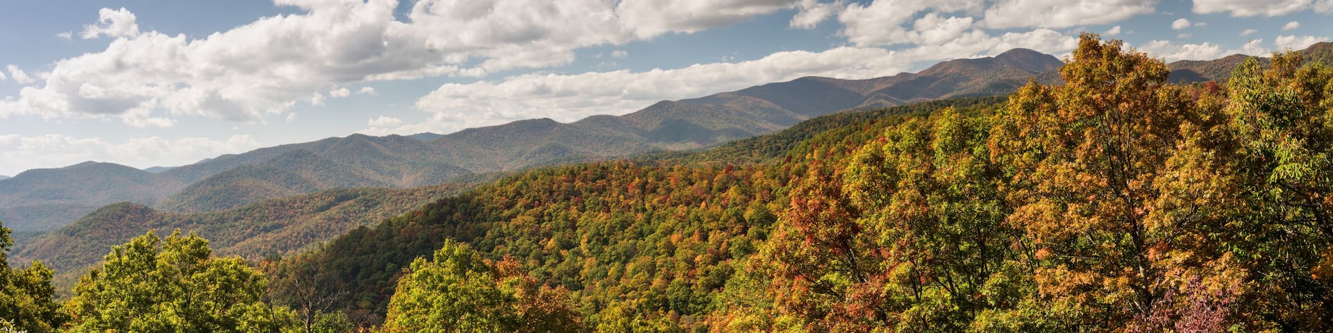 A mountainous landscape with autumn foliage and a clear sky.