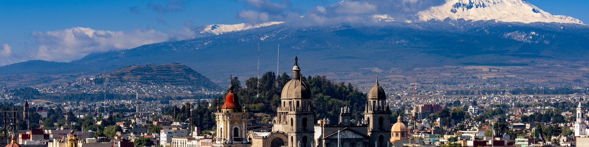 Toluca colonial cathedral and historic downtown with snow-capped Nevado de Toluca volcano under clear blue sky, State of Mexico, Mexico