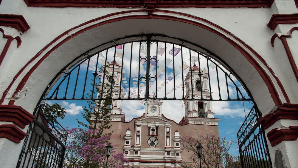 An arched gate with a clock tower in the background.