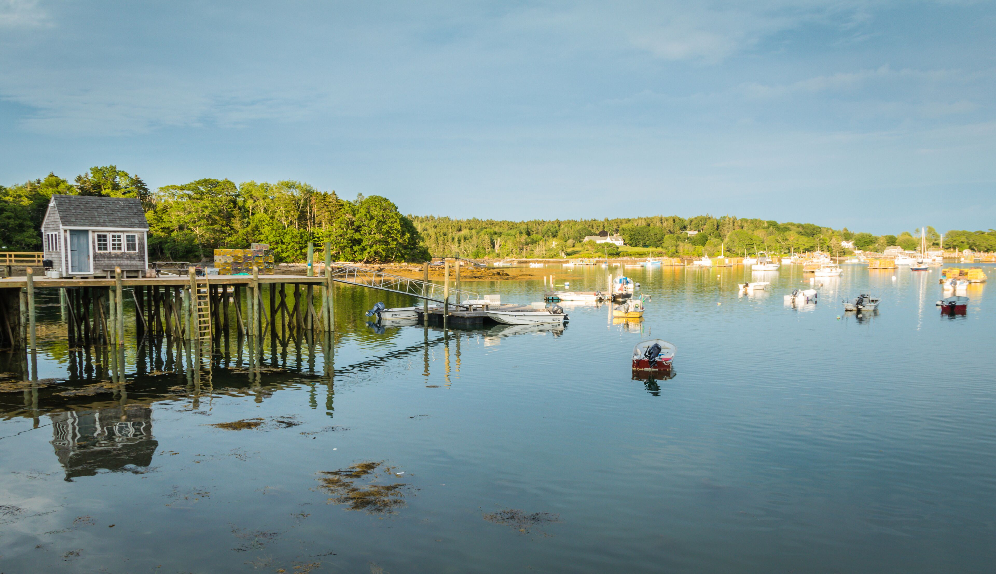 Lobster boats are moored in the harbor at dusk in Friendship, Maine