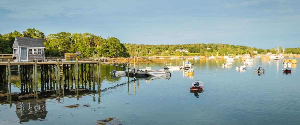 Lobster boats are moored in the harbor at dusk in Friendship, Maine