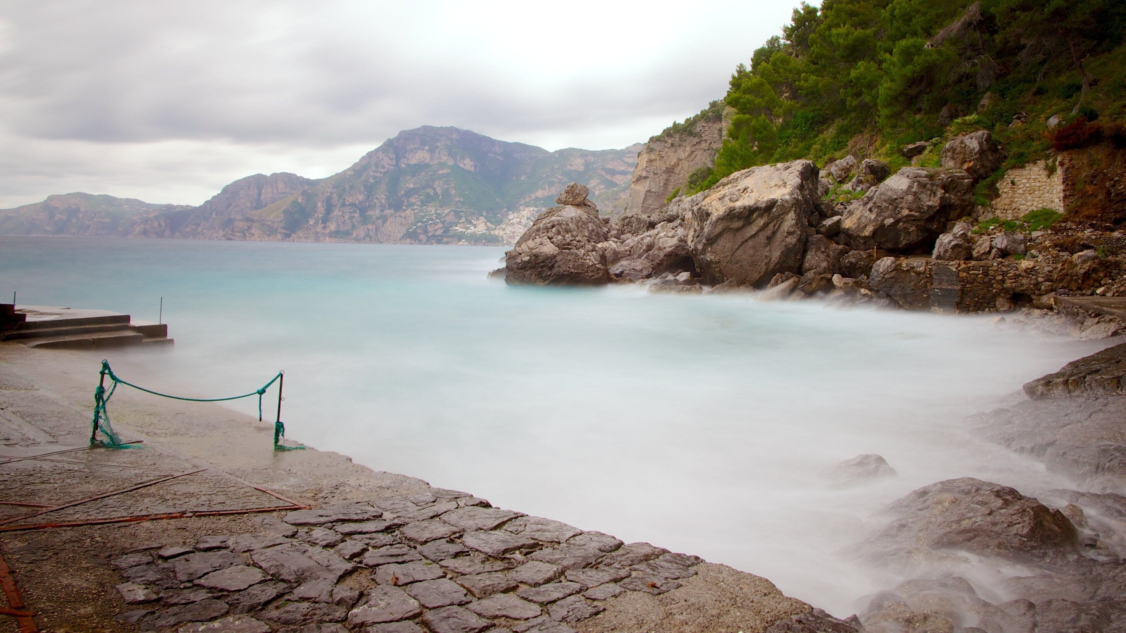 Praiano som inkluderer tåke og stenete kystlinje