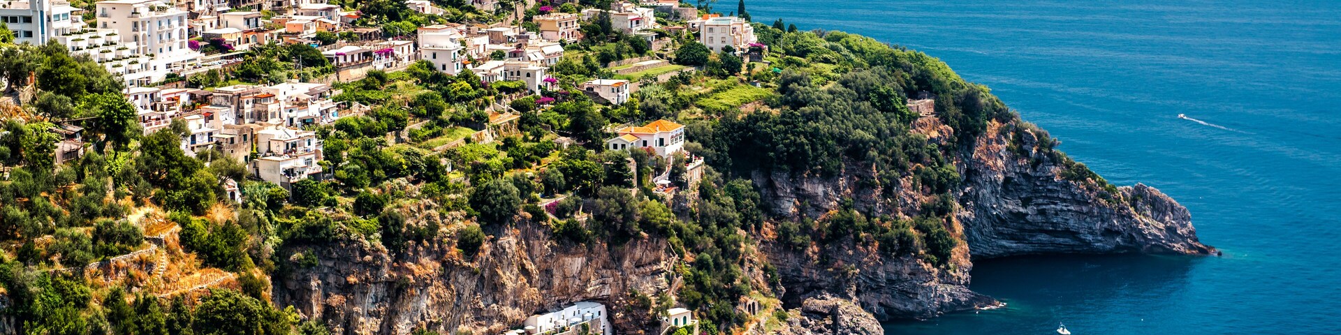 Un pueblo costero con edificios en una colina con vistas al mar.