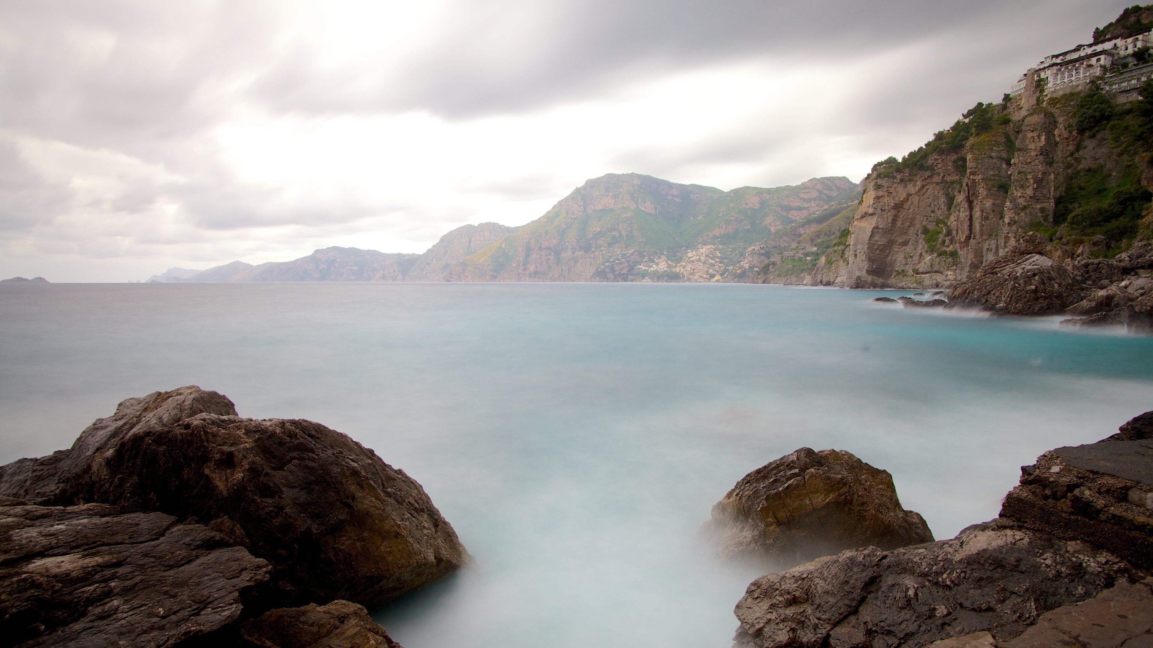 Praiano featuring rocky coastline and mist or fog