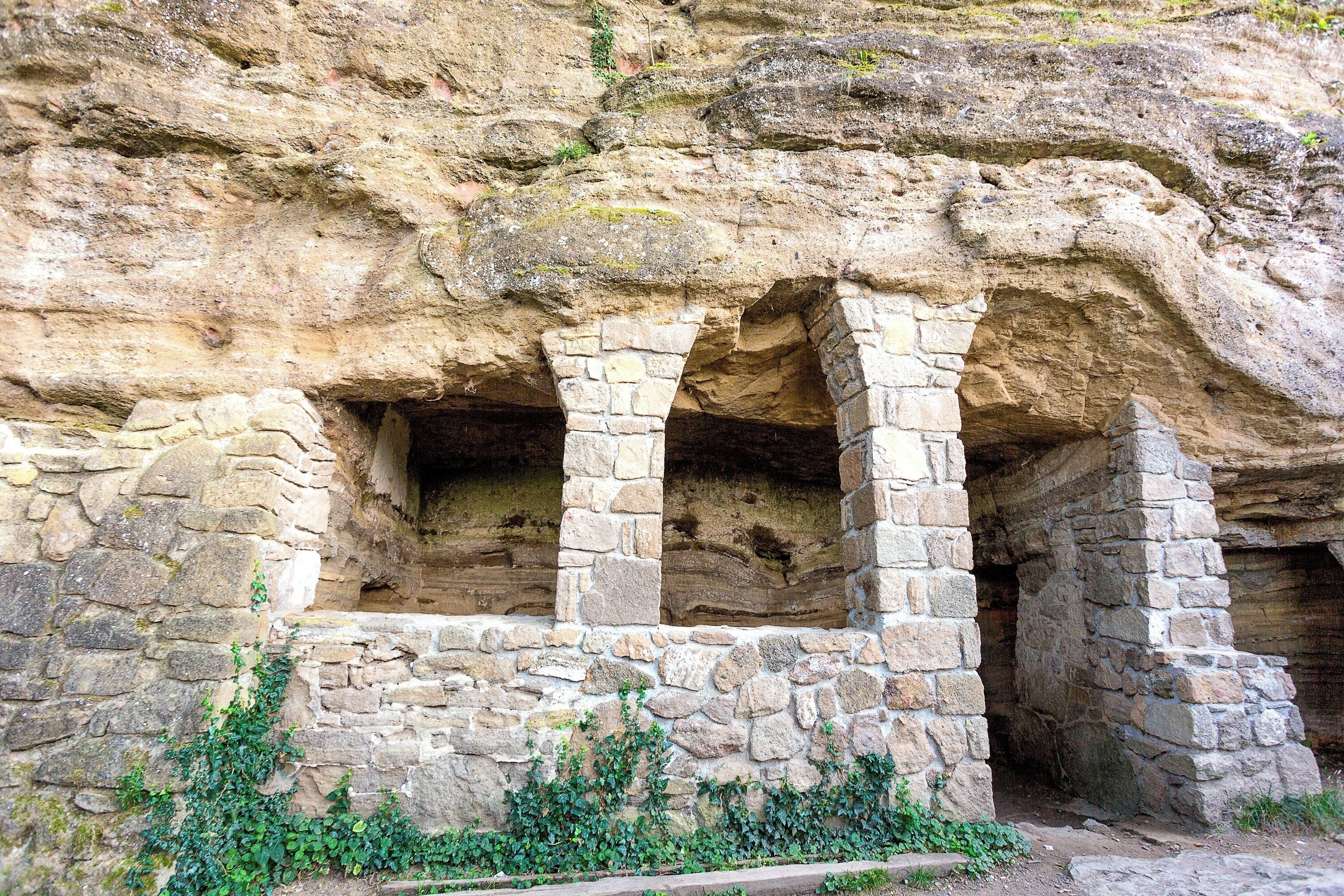 #Details

These small caves were carved into the high basalt tufa cliffs on the eastern side of the Óvár hill. Russian monks are reputed to have lived here brought here from the Great Principality of Kiev by the wife of the Hungarian king I. Endre around the year 1050. Only three groups of cells are visible today, the rest were buried in 1952 by a rockfall. The caves are accessible via a marked trail.
