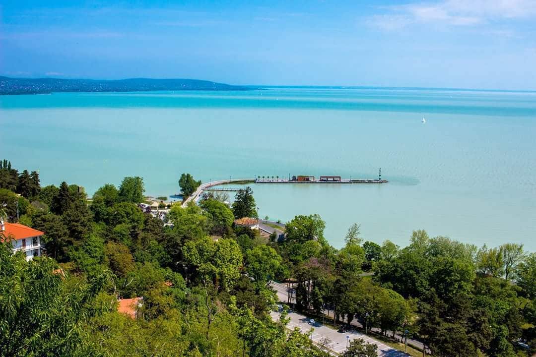 Un paisaje costero con un puente, un muelle y una masa de agua.