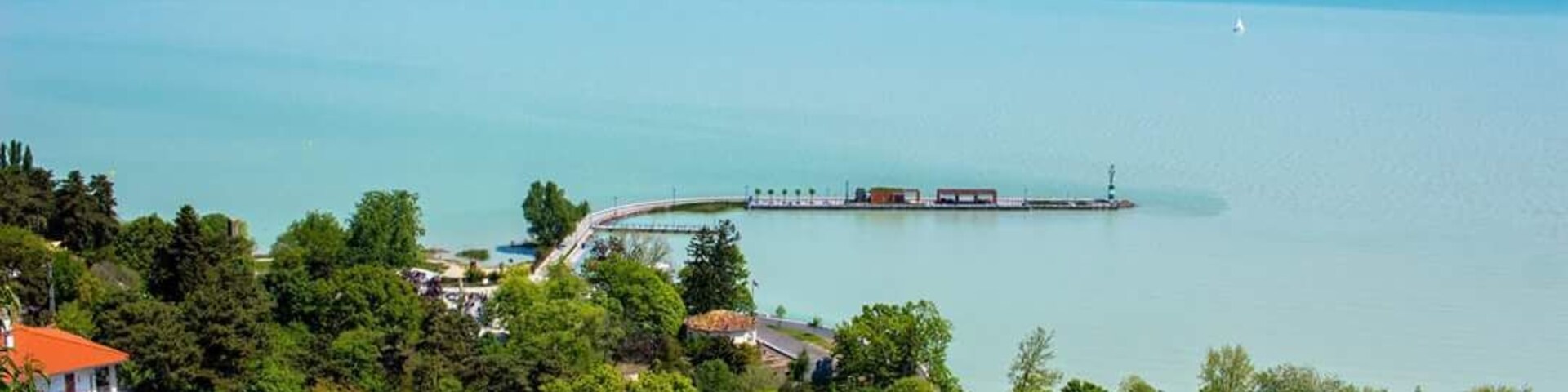 Un paisaje costero con un puente, un muelle y una masa de agua.