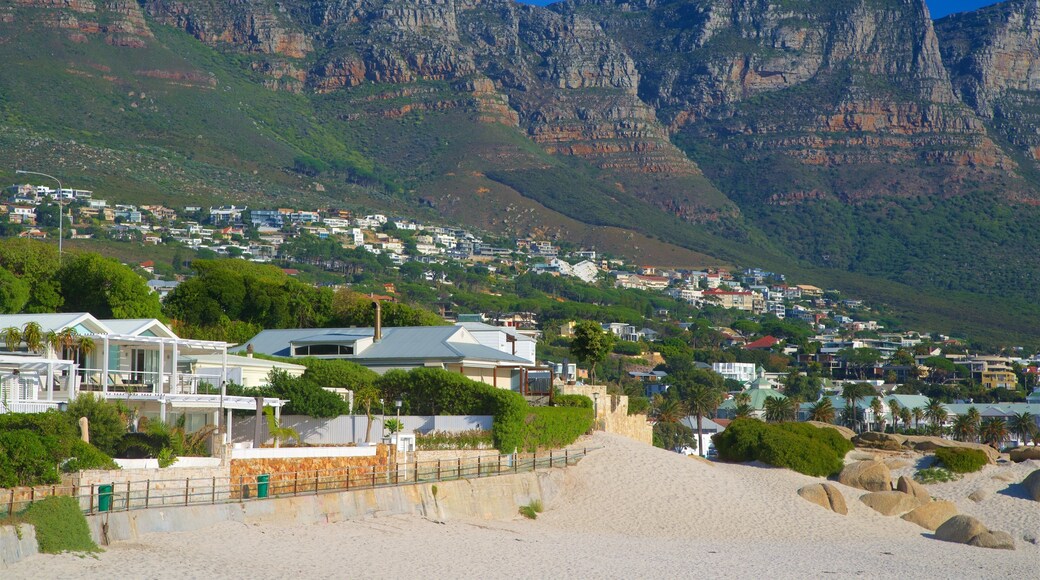 Camps Bay which includes a coastal town, a sandy beach and rocky coastline