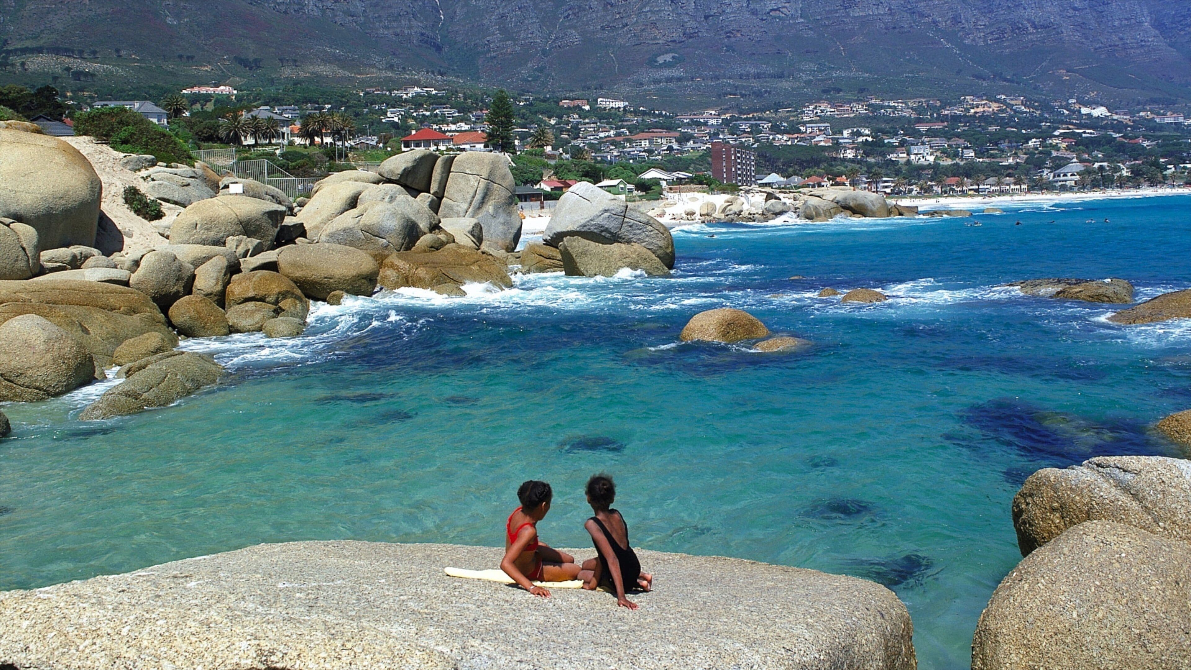 Camps Bay som viser en bugt eller havn, en kystby og udsigt over landskaber