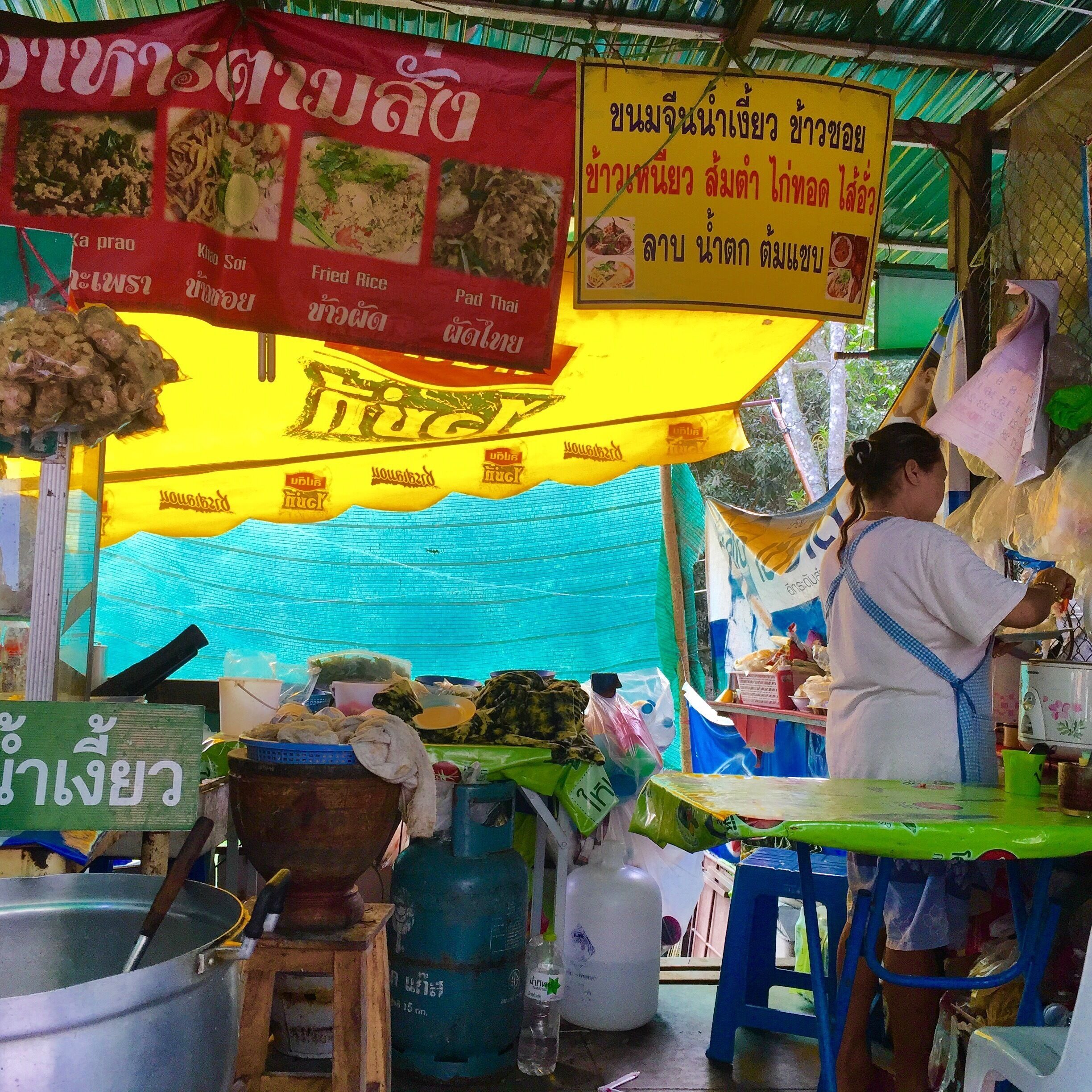 A street food stall with a signboard listing various dishes.