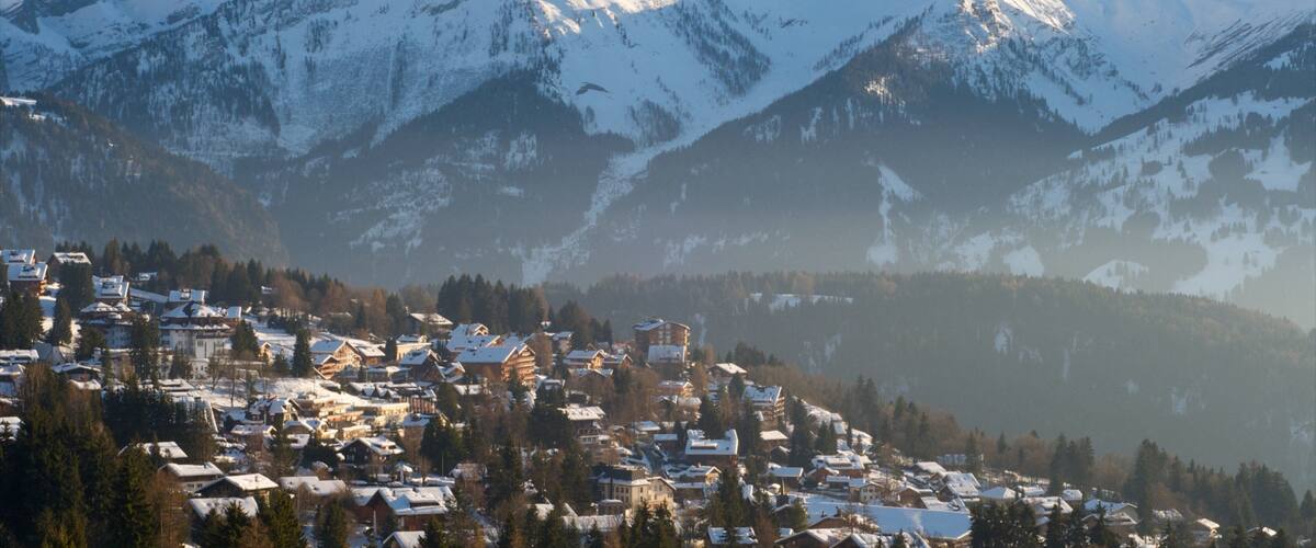 A snow-covered mountain range with a town nestled at the base.