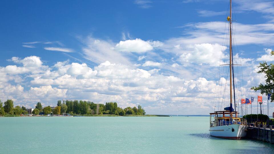A sailboat docked at a pier with a clear sky and calm water.