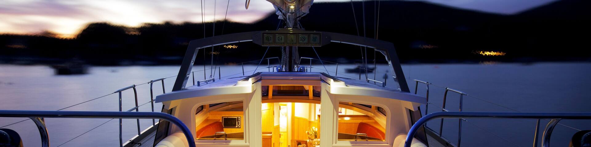 A boat's deck with two screens displaying maps, a central seating area, and a control panel.