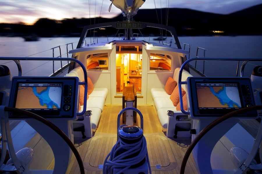 The deck details and interior of luxury sailing yacht "Isobel" glow at dusk as she is anchored off the coast of Maine. "Isobel" is a cold molded Spirit of Tradition yacht, designed by Stephens & Waring and built by Brooklin Boatyard, Maine
