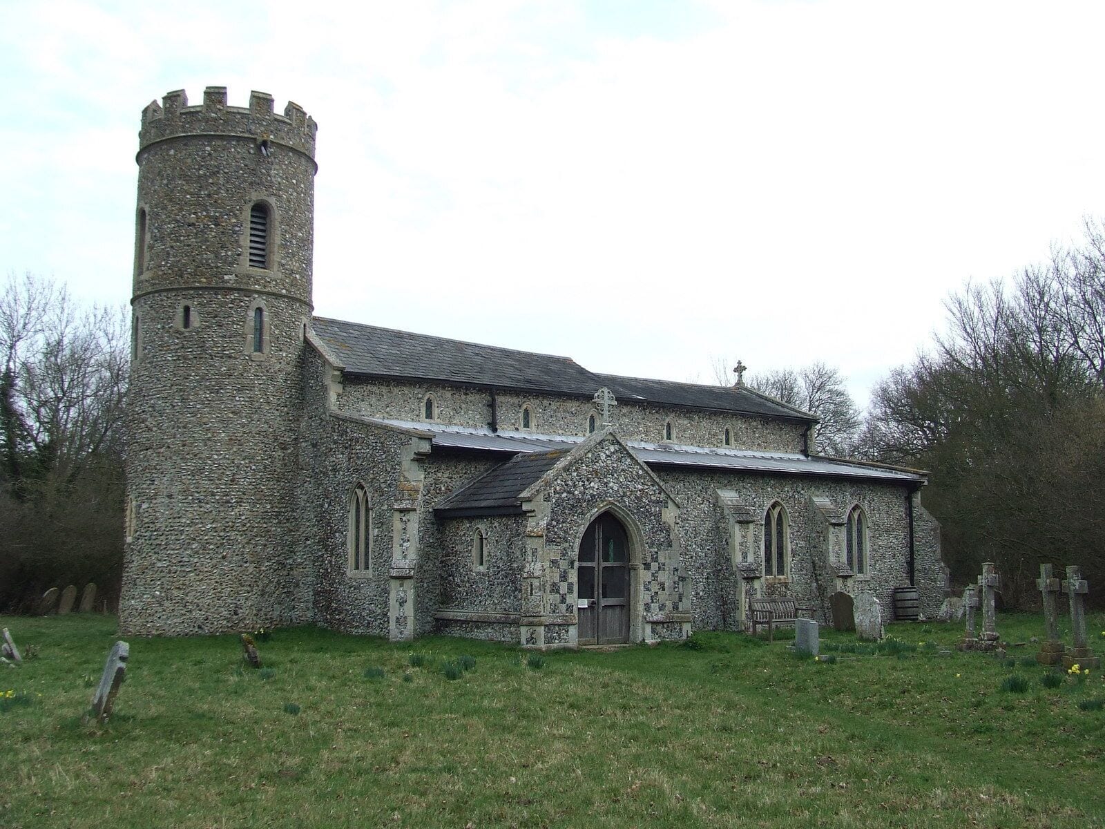 A stone church with a tower and arched windows.