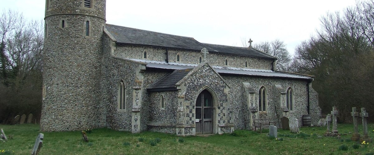 A stone church with a tower and arched windows.