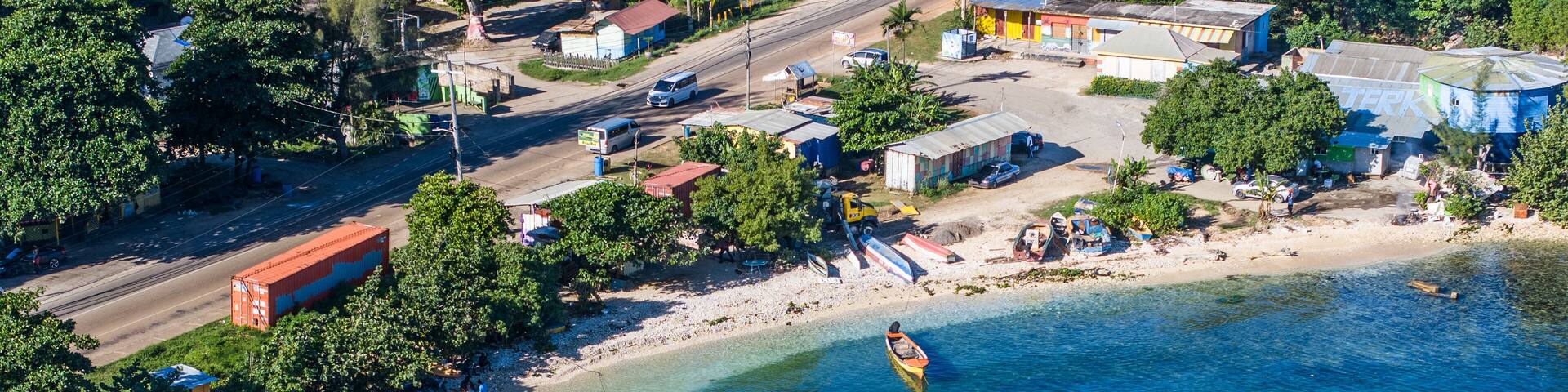 A coastal town with clear blue waters, boats, and buildings.