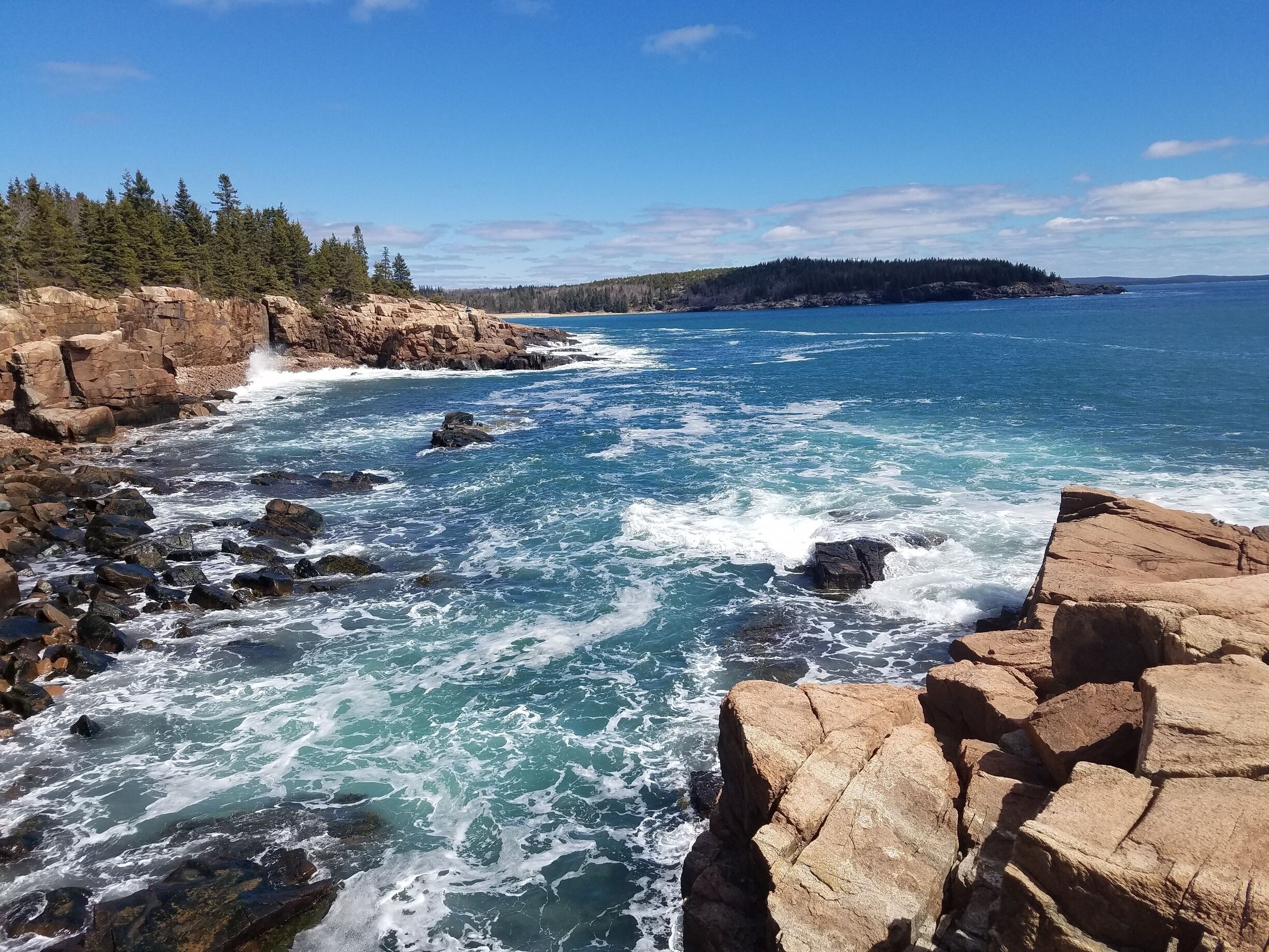 A rocky coastline with waves crashing against the rocks.