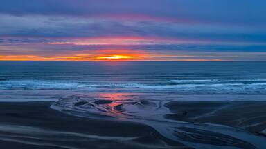 USA, Washington State, Copalis Beach. Sunset panoramic where Boone Creek enters Pacific Ocean.