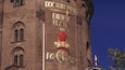 A brick building with the inscription "DOCTRINUM DIRIGE IN" and a red heart-shaped object with a crown.