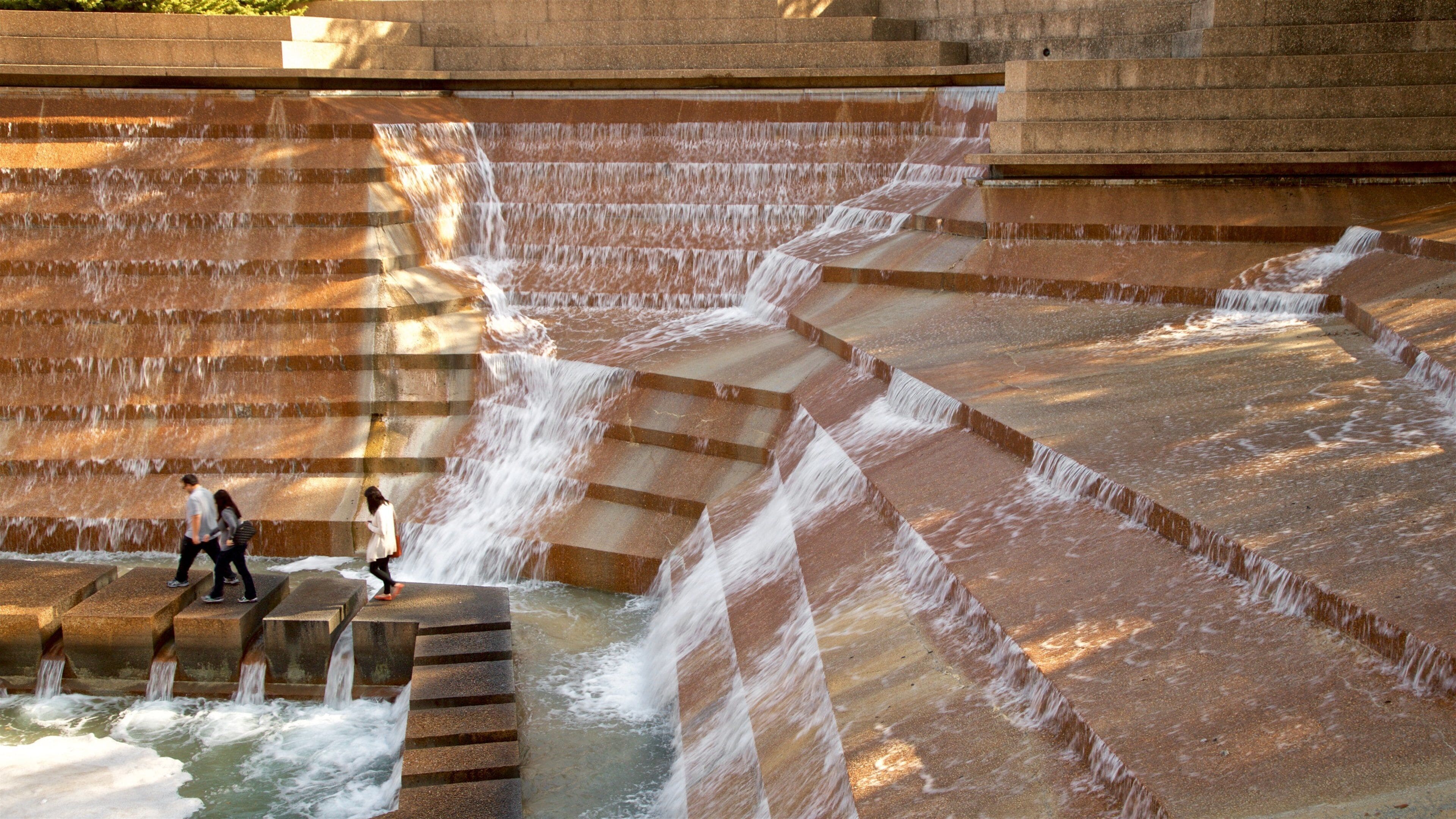 Fort Worth Water Gardens som viser et springvand såvel som en lille gruppe mennesker