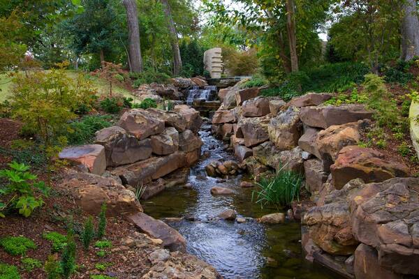 Beautiful rock formations and flowing water create a serene atmosphere in Dallas Arboretum