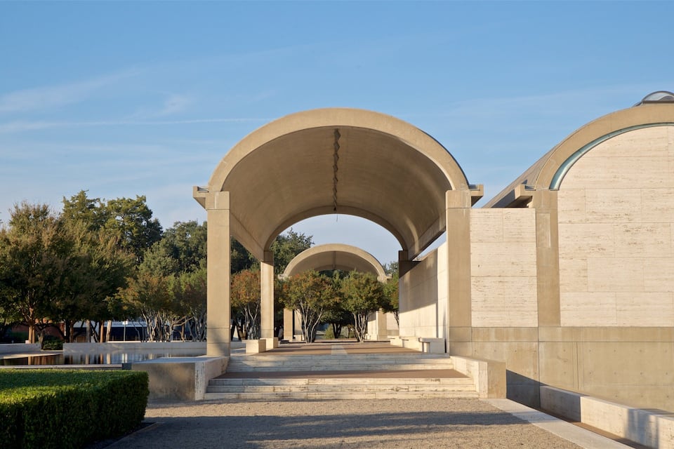 A series of arches leading to a large building with inscriptions.