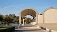A series of arches leading to a large building with inscriptions.