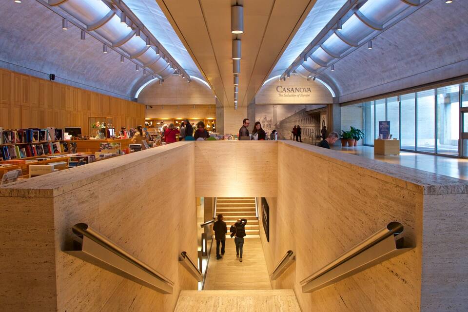 Interior d'una biblioteca espaiosa, amb una escala central, prestatges de fusta i un rètol que diu 'CASANOVA'.