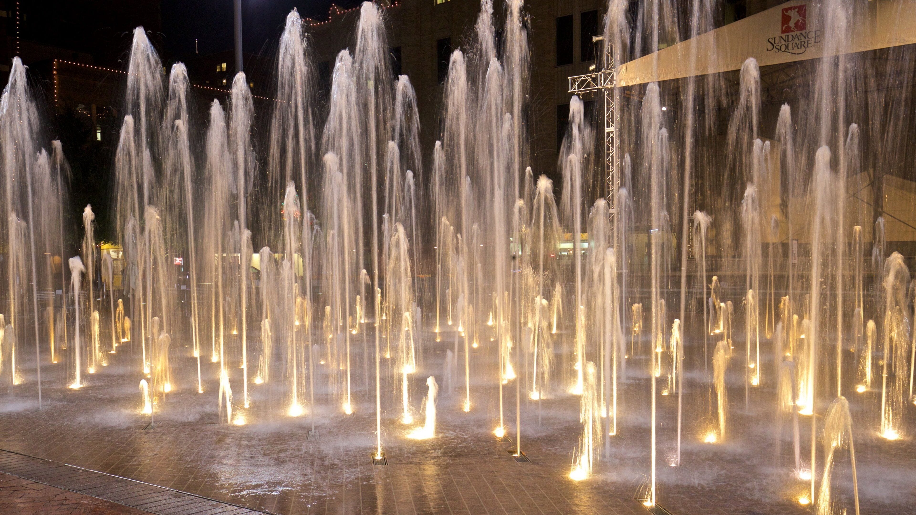 Sundance Square showing night scenes and a fountain