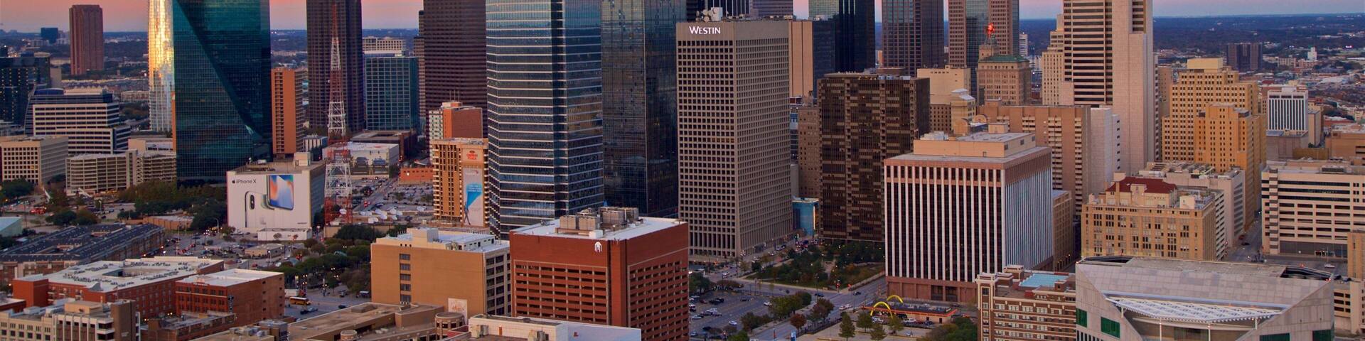 Reunion Tower which includes a city, a sunset and a high rise building