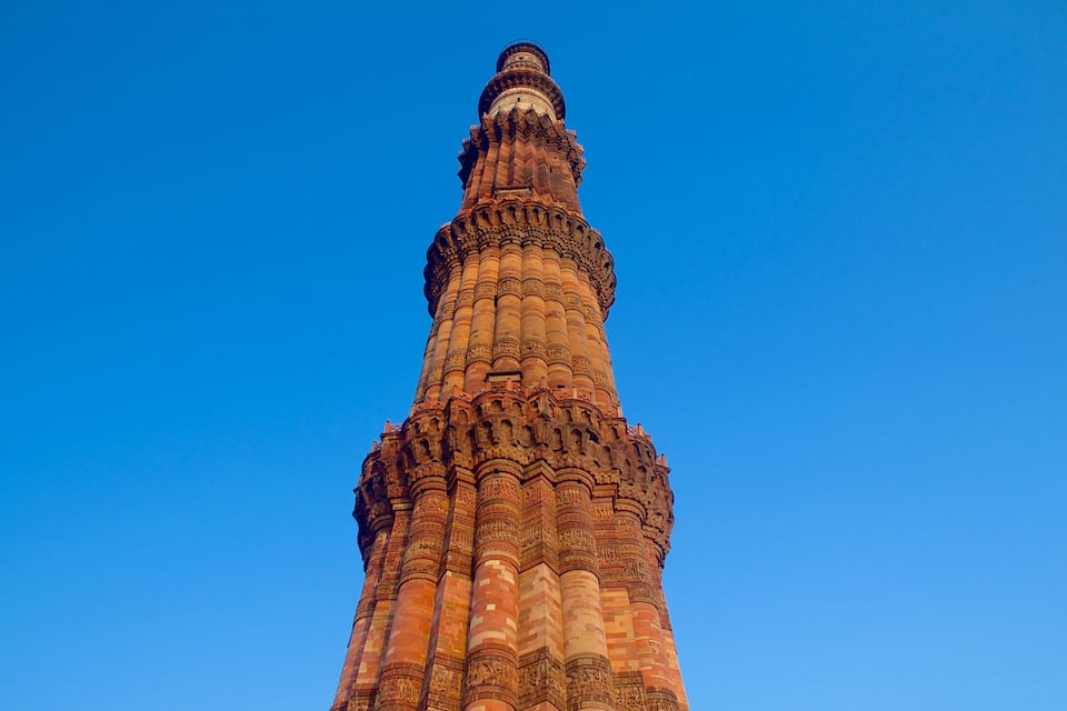A tall, intricately carved tower against a clear blue sky.
