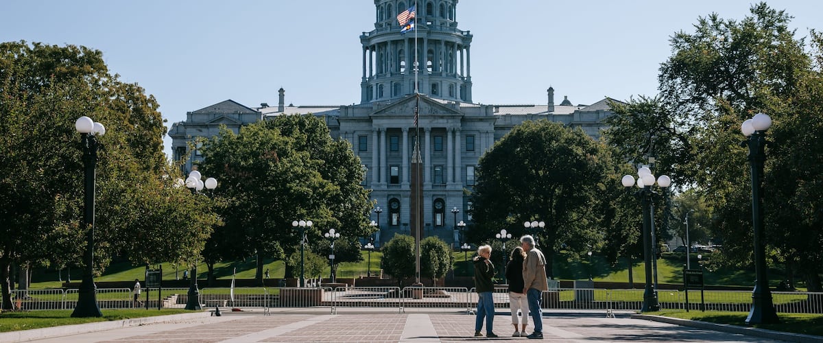Colorado State Capitol Building showing a park and heritage architecture as well as a small group of people