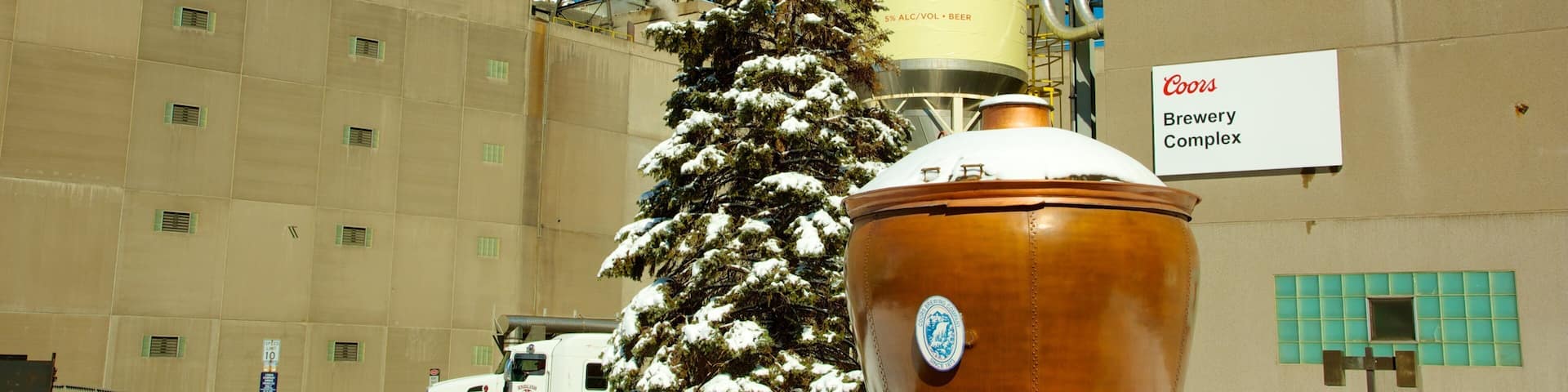 A Coors Brewery Complex with a large beer tank and a snow-covered Christmas tree.