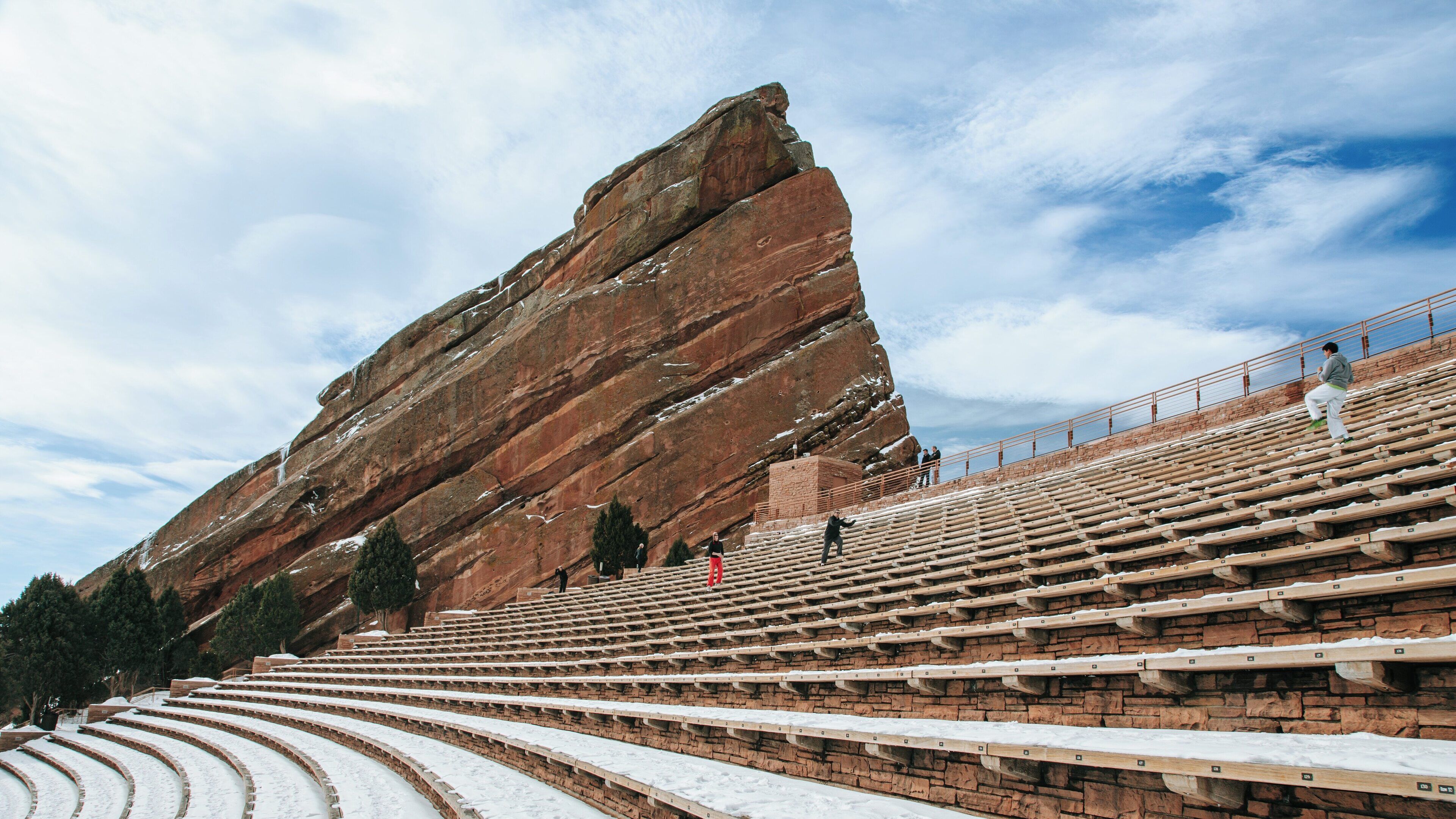 Rock formations and seating at Red Rocks Amphitheater in Morrison Colorado during winter with visitors exploring the area
