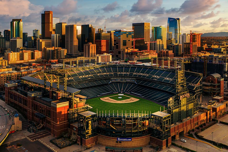 A baseball stadium with a city skyline in the background.