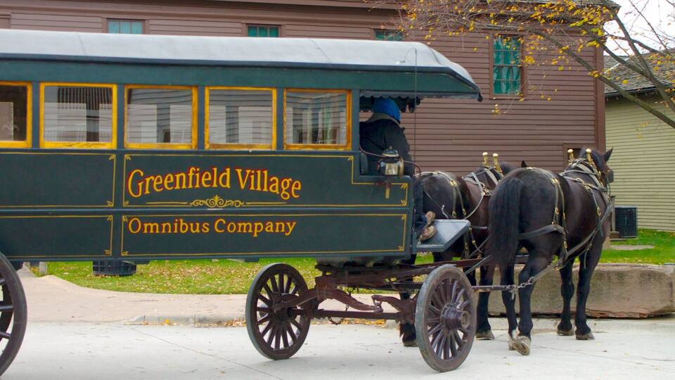 A horse-drawn carriage with the text "Greenfield Village Omnibus Company" on its side.